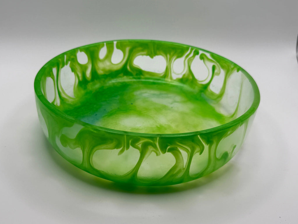 Green glass bowl with decorative pattern on a white background