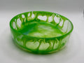 Green glass bowl with decorative pattern on a white background