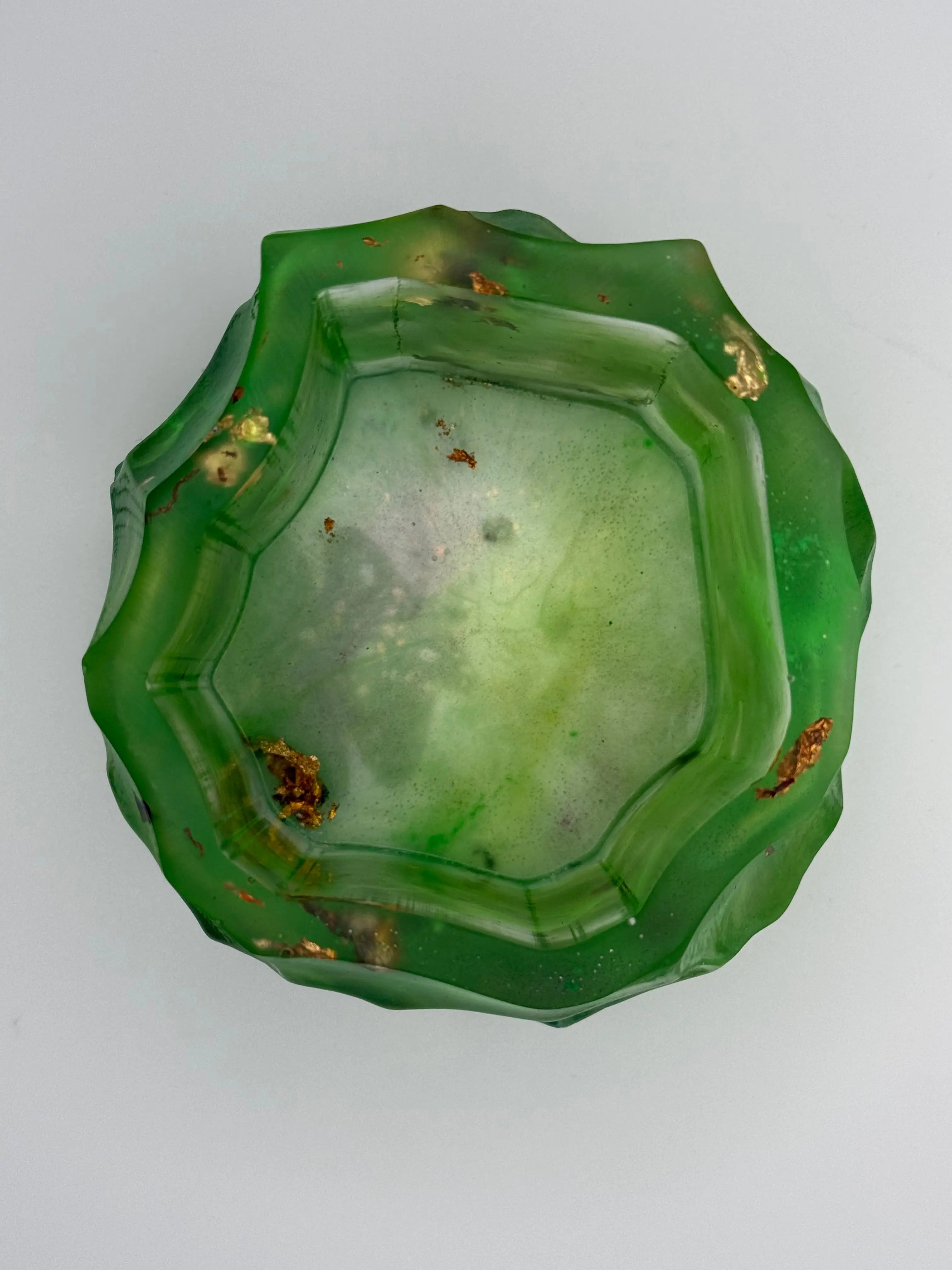 Green resin bowl with gold and copper leaf on a white background