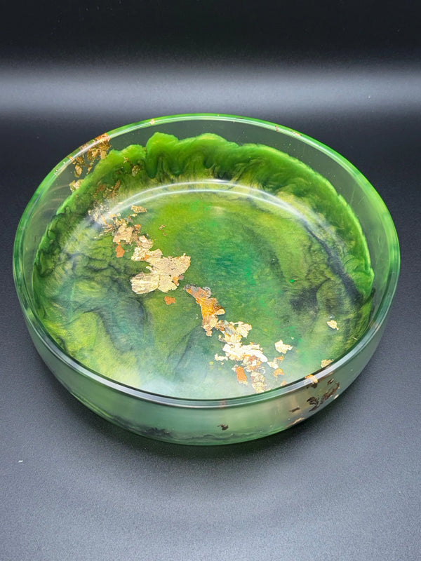 Green and black glass resin bowl with gold leaf on a dark background