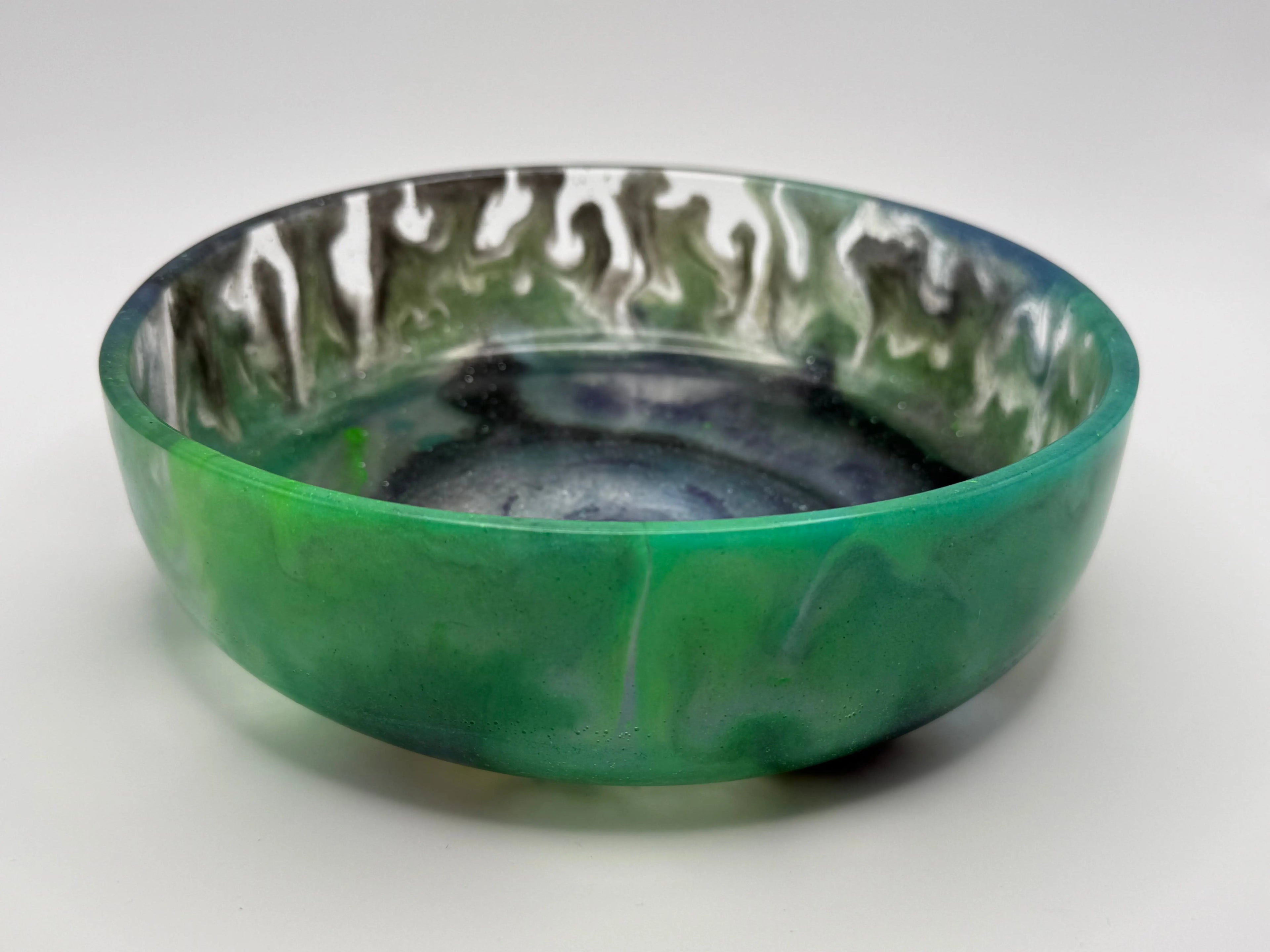 Abstract green and black resin dish on white background