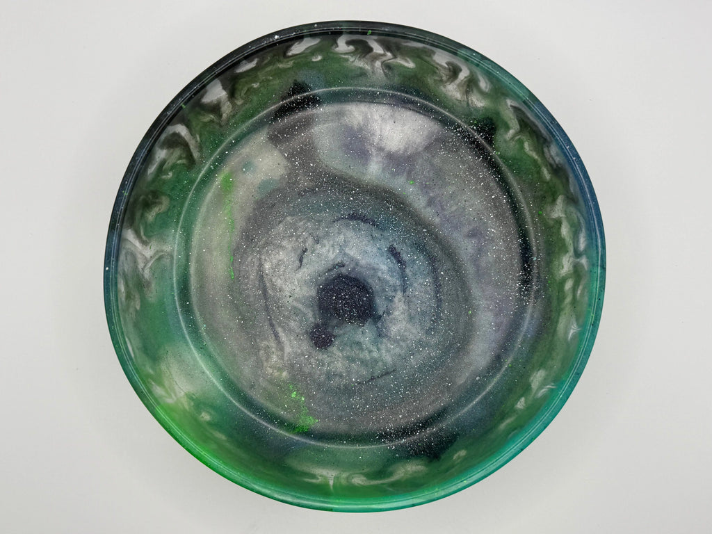 Green resin bowl with decorative patterns on a white background