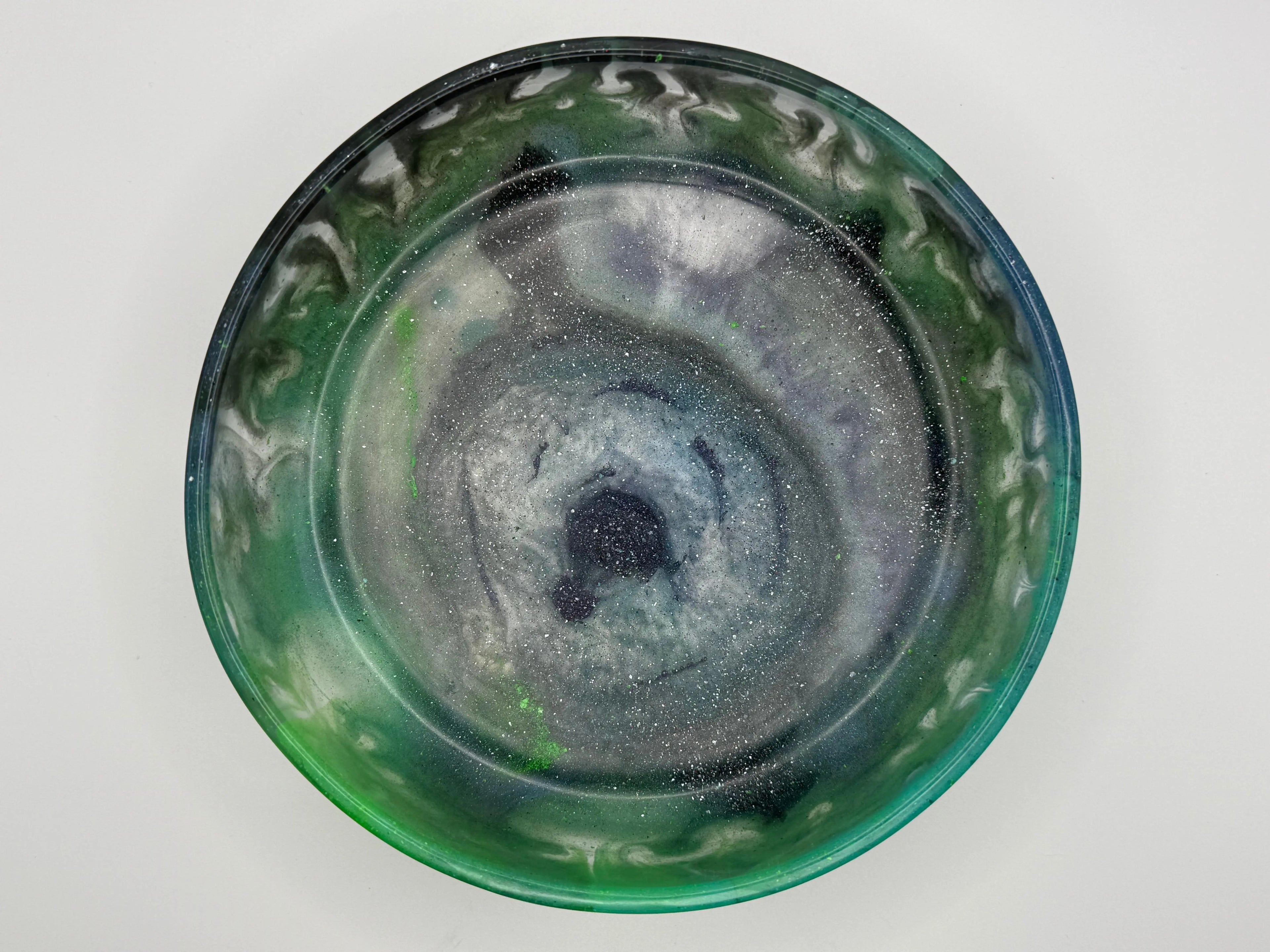 Green resin bowl with decorative patterns on a white background