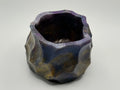 Hexagonal resin vase with a textured surface on a light gray background