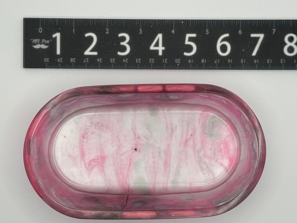 Marbled pink and gray resin with ruler for scale on a white background