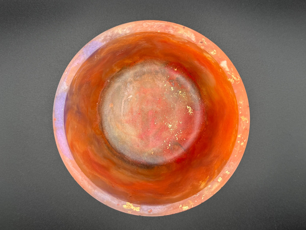 Close-up of a orange and purple vase with a dark gray background