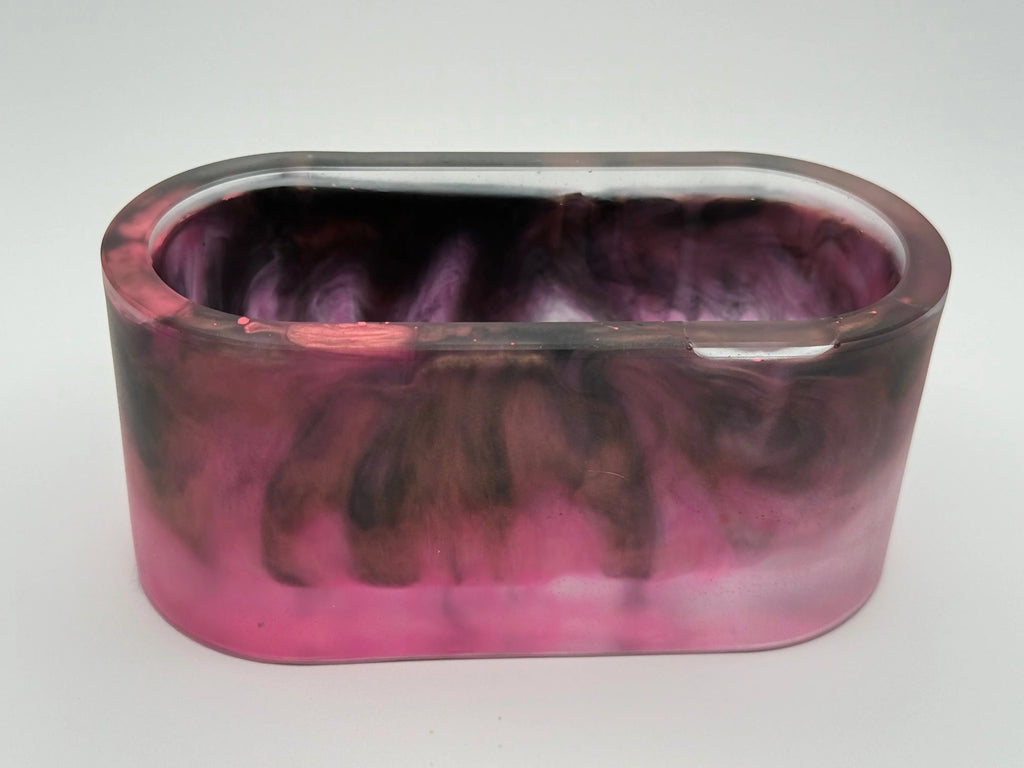 Oval resin bowl with marbled pink and purple design on a white background