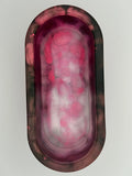 Oval-shaped container with florescent pink and white on a light gray background