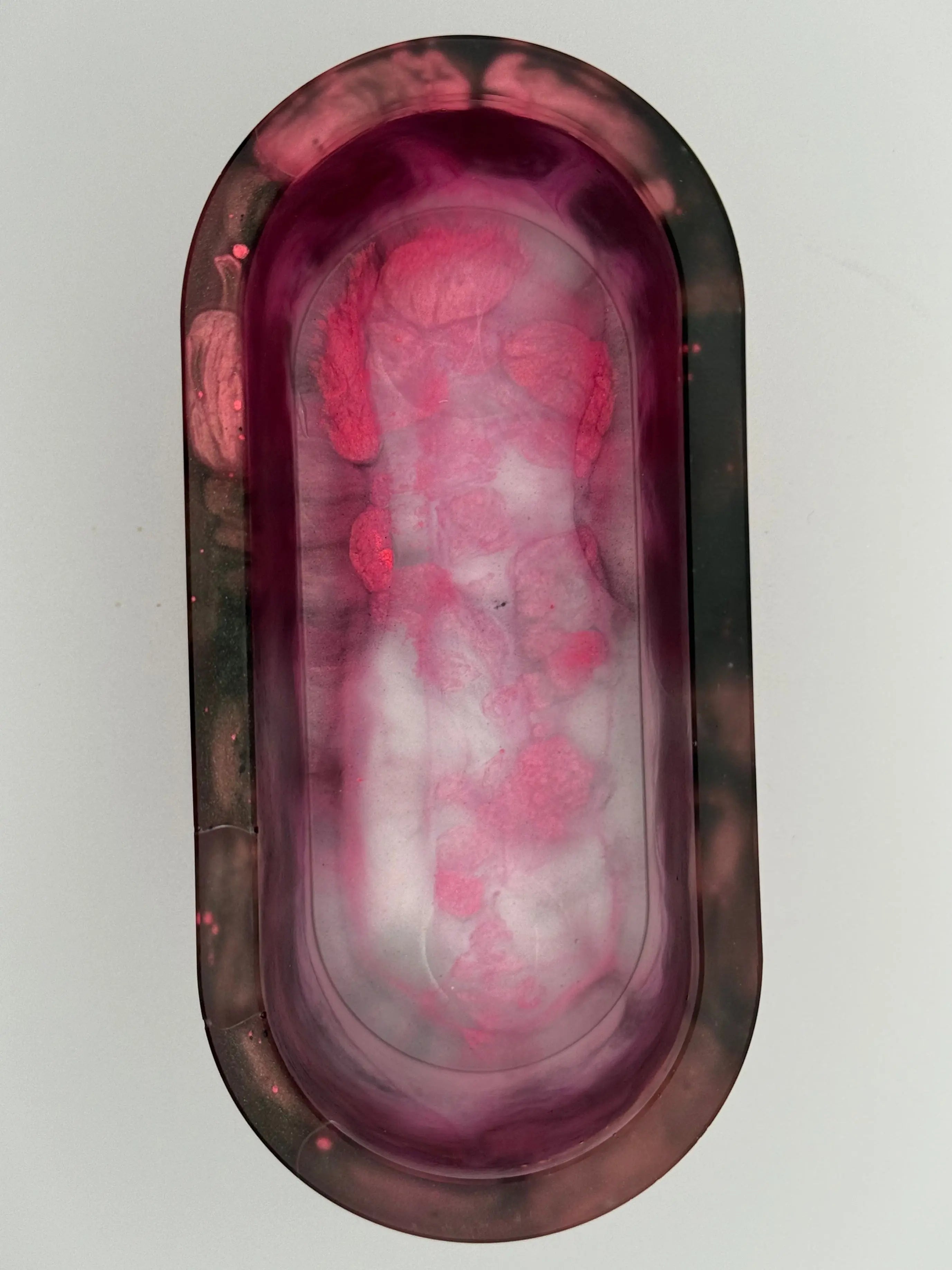 Oval-shaped container with florescent pink and white on a light gray background