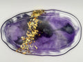 Decorative plate with purple and gold design on a white background