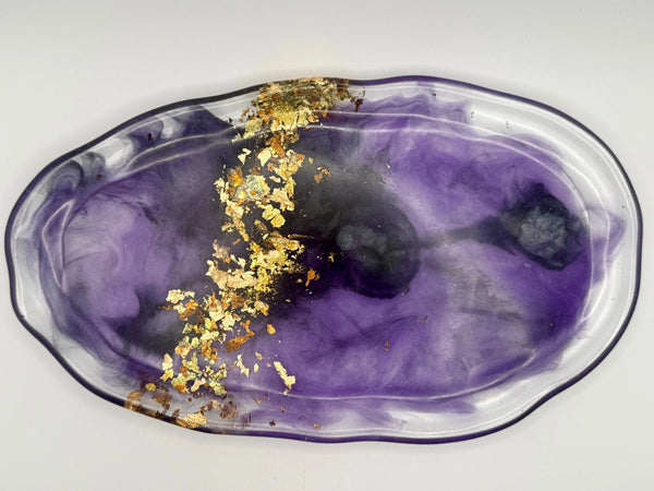 Decorative plate with purple and gold design on a white background