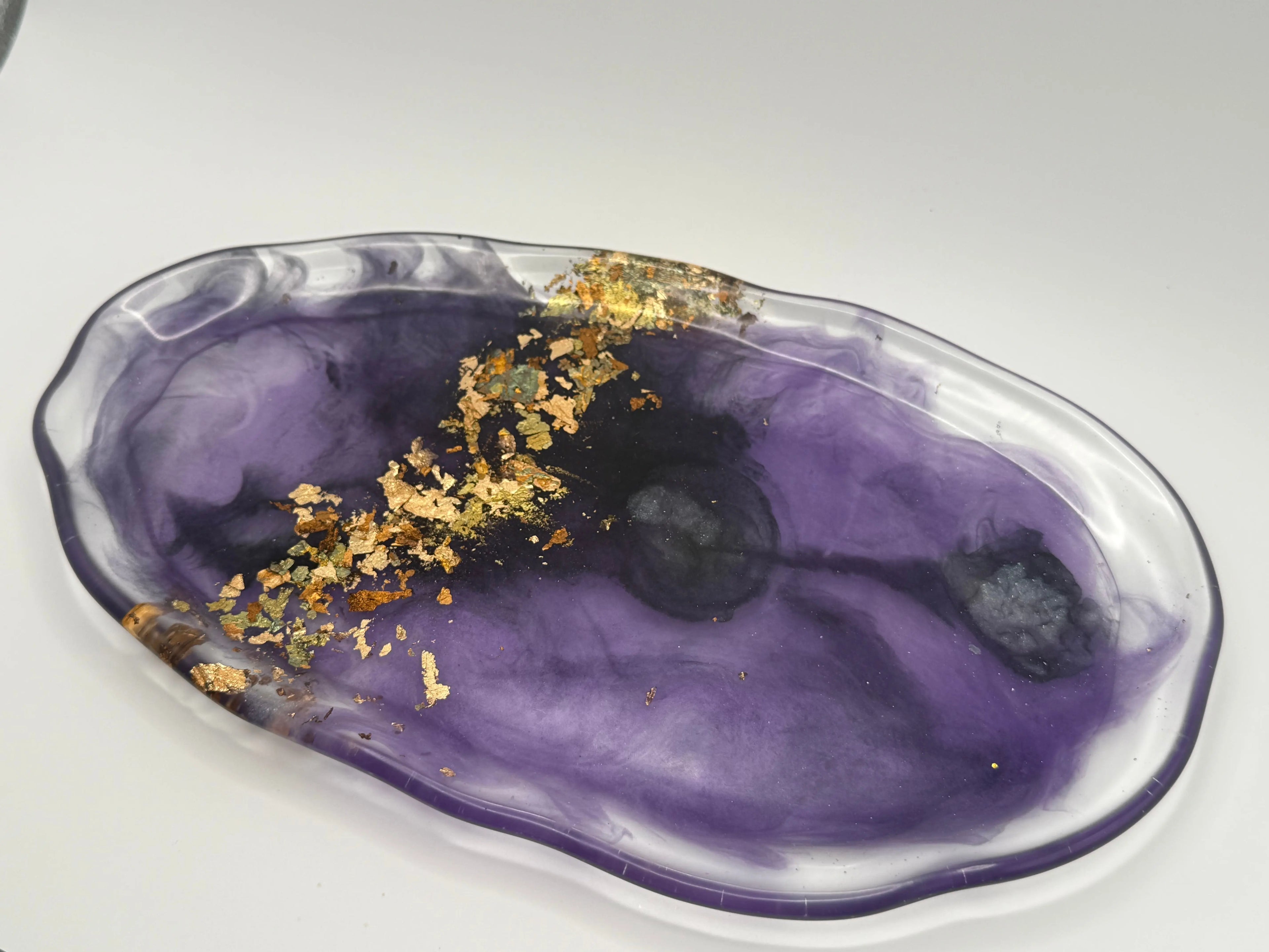 Purple resin dish with gold leaf on a white background