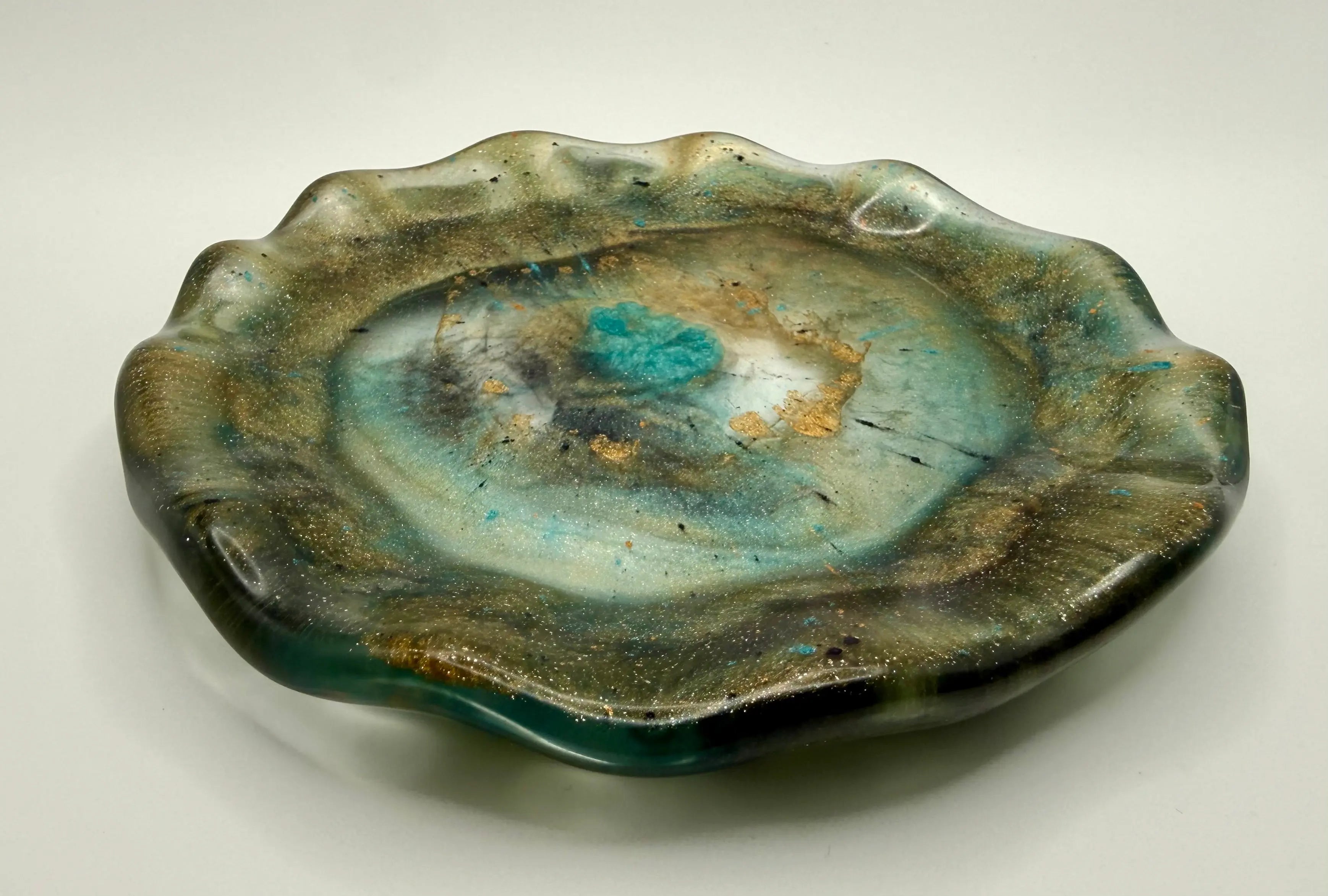 Earthy jeweled toned free form resin plate on white background