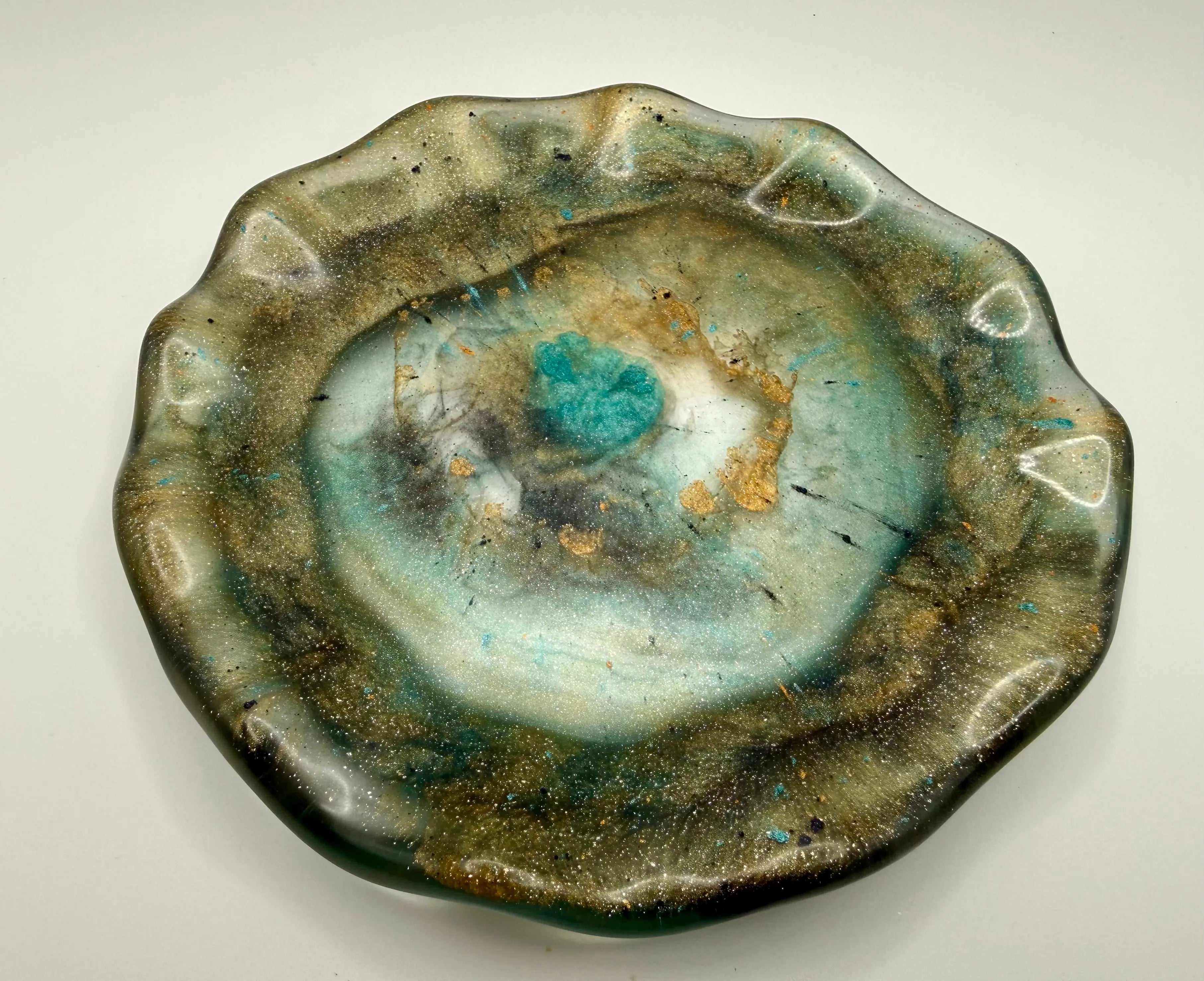 Artistic resin plate with green and brown organic design on a white background