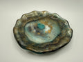 Earthy jeweled tone plate with a textured surface on a plain background