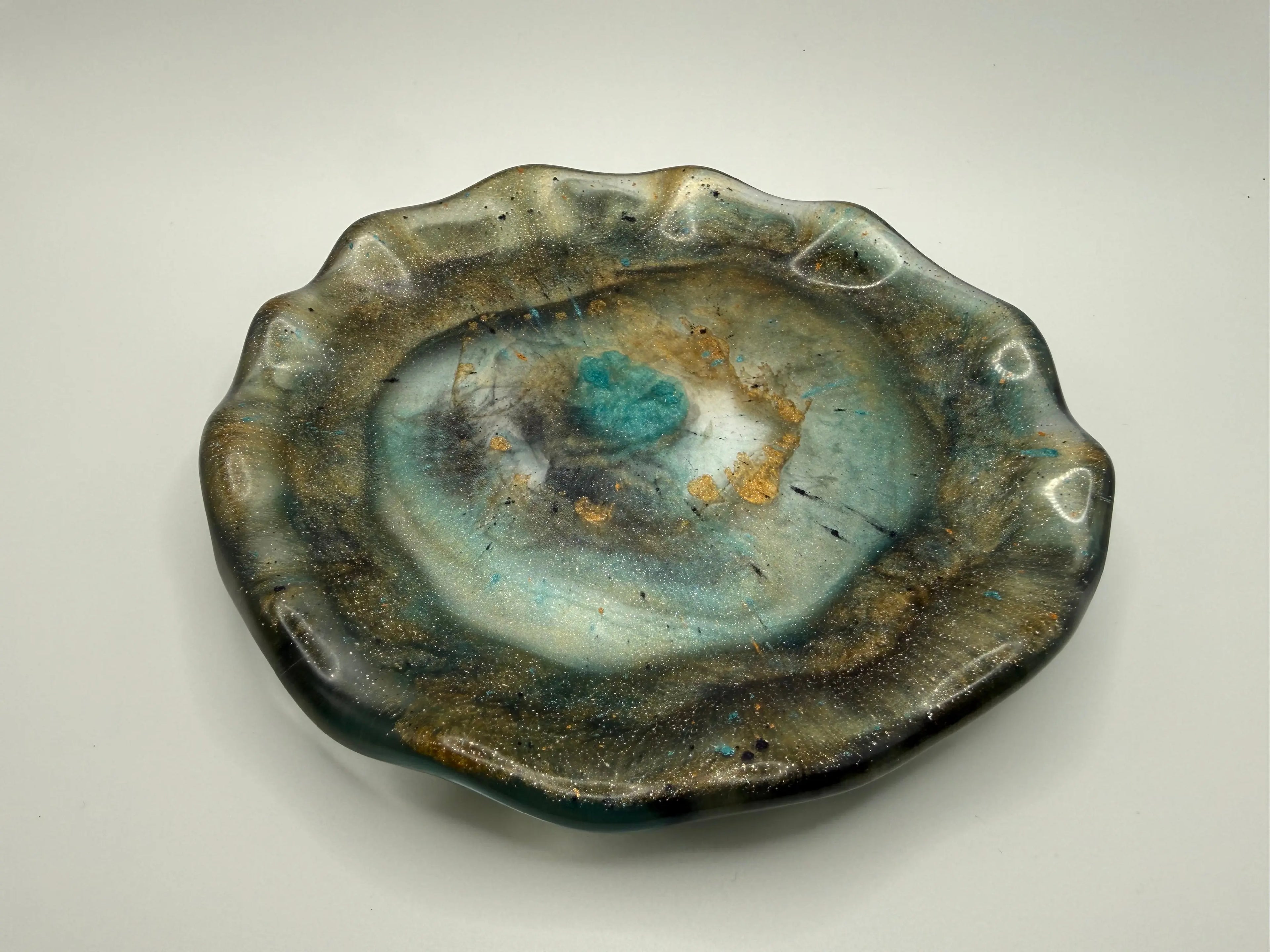 Earthy jeweled tone plate with a textured surface on a plain background