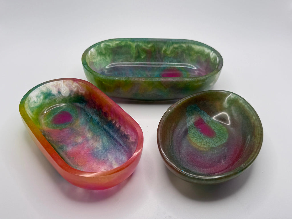 Three colorful resin dishes on a white background